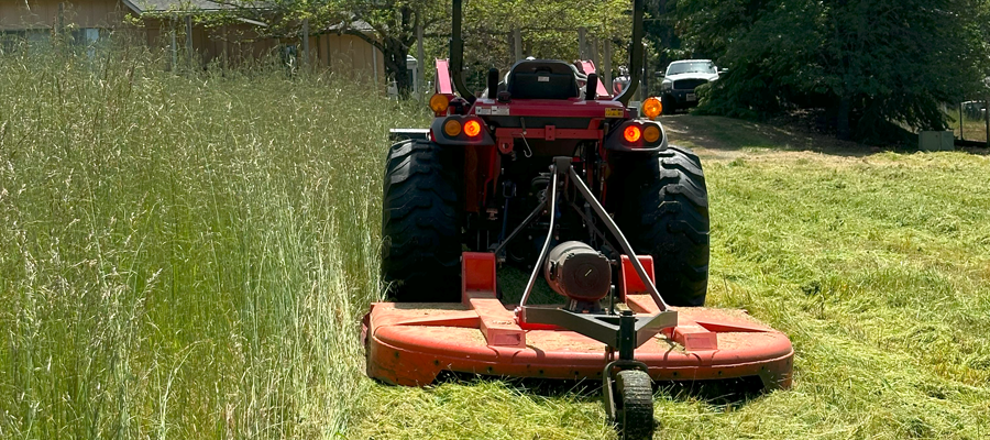 Defensible space field mowing for wildfire safety in Southern Oregon.